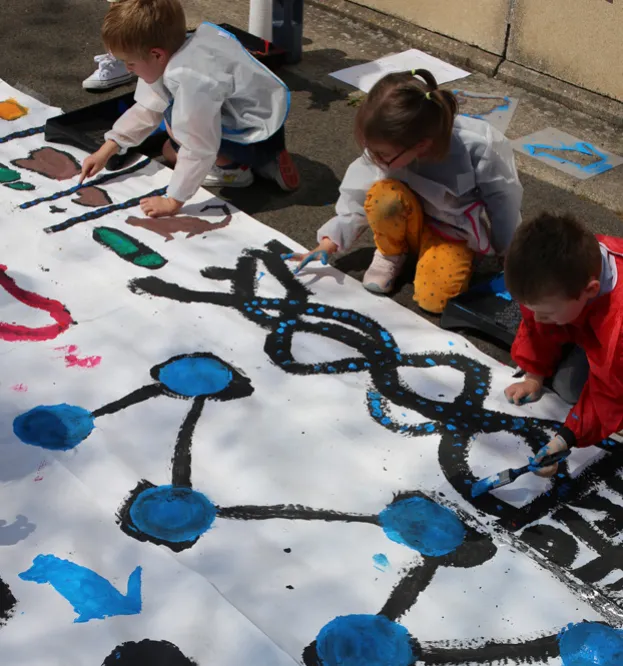 Enfants peignant des formes bleues et noires