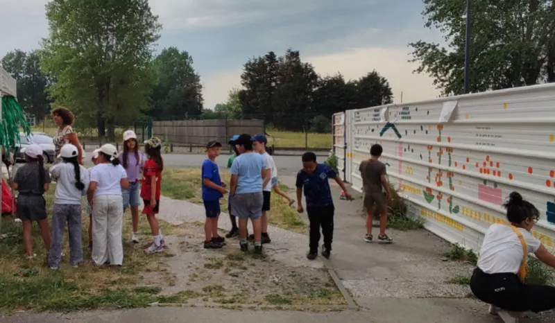 Enfants et adultes réunis devant le mur pendant l’atelier
