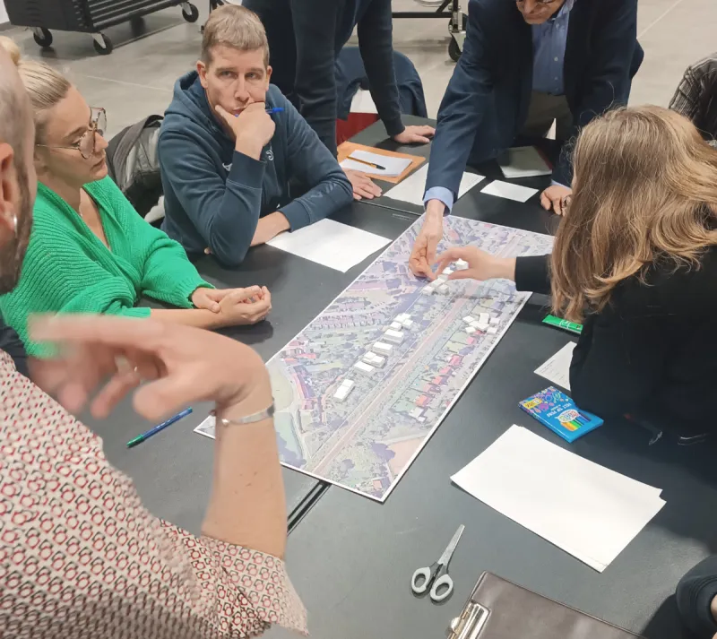 Participants penchés sur un plan du site lors d’un atelier