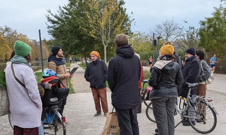 Balade urbaine : un groupe d’habitants à pied et à vélo dans un parc
