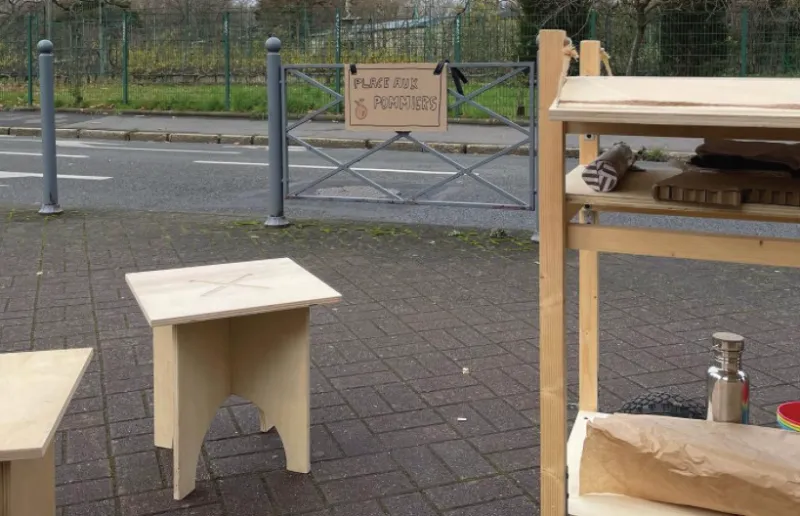 Tabouret et étal en bois installés sur la placette